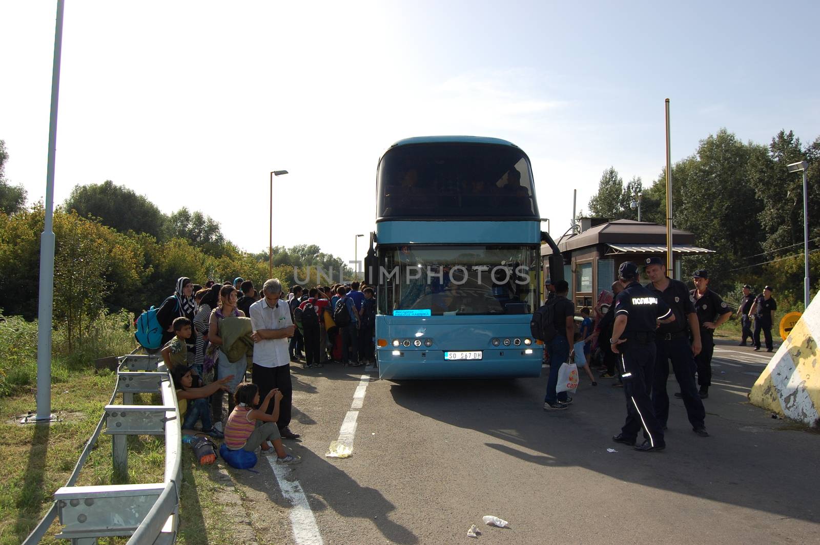 SERBIA, Border with Croatia: Refugees gather around their bus as hundreds are stranded at the Serbian-Croatian border on September 18, 2015 after Croatia decided to shut their border with Serbia.This decision was made after more than 11,000 refugees entered Croatia in a single day. Refugees had to spend entire night and half of the next day at the border. Local authorities in Serbia have organized bus transportation to take the refugees from the border to the reception camps.