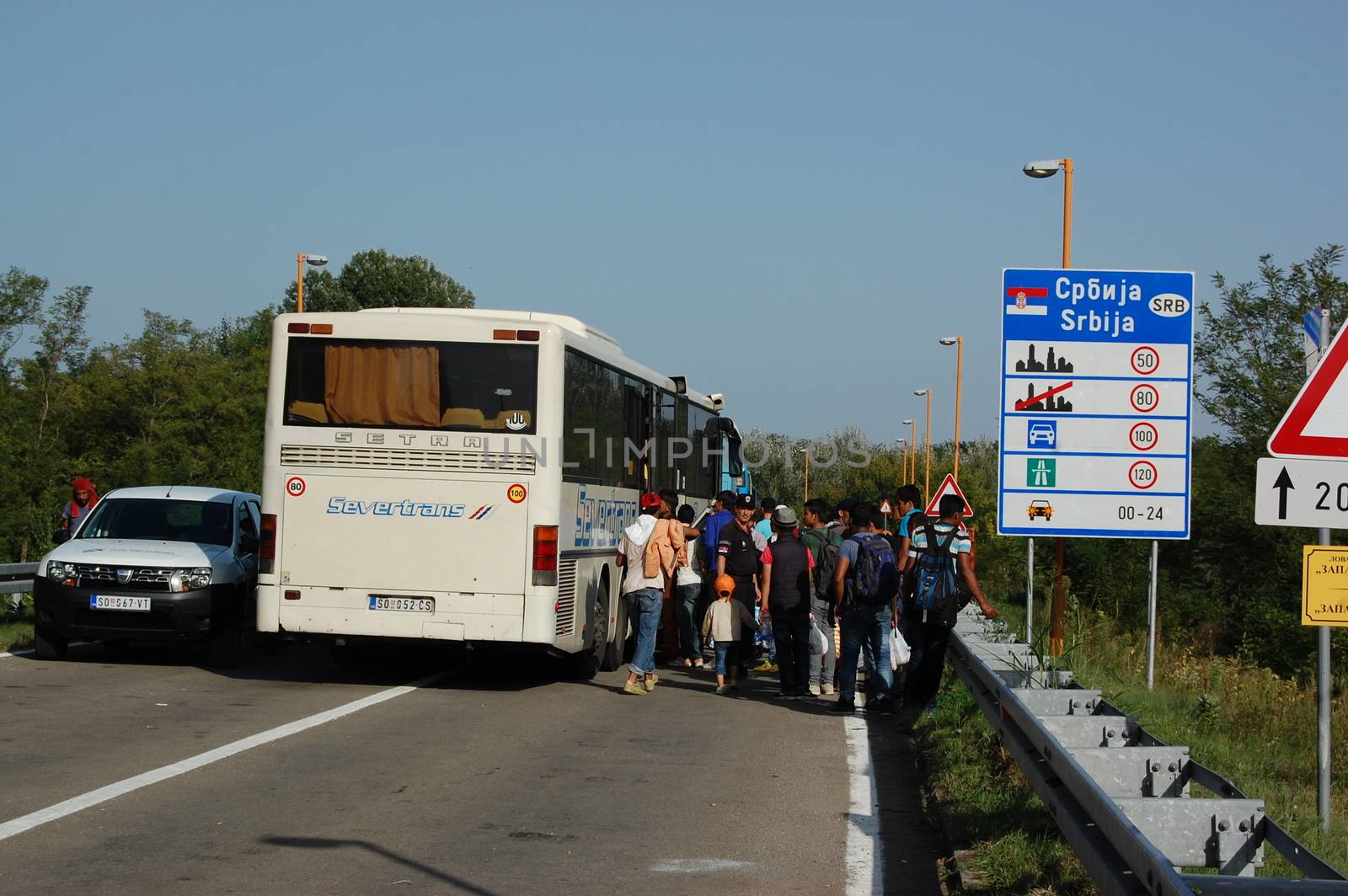 SERBIA, Border with Croatia: Refugees gather around their bus as hundreds are stranded at the Serbian-Croatian border on September 18, 2015 after Croatia decided to shut their border with Serbia.This decision was made after more than 11,000 refugees entered Croatia in a single day. Refugees had to spend entire night and half of the next day at the border. Local authorities in Serbia have organized bus transportation to take the refugees from the border to the reception camps.