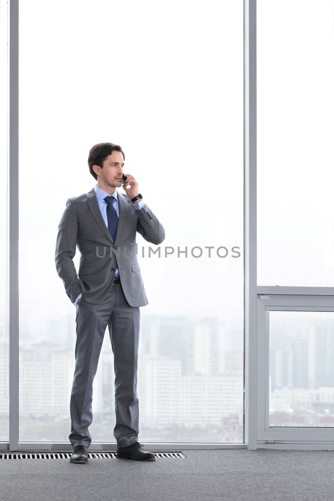Businessman talking by phone by ALotOfPeople
