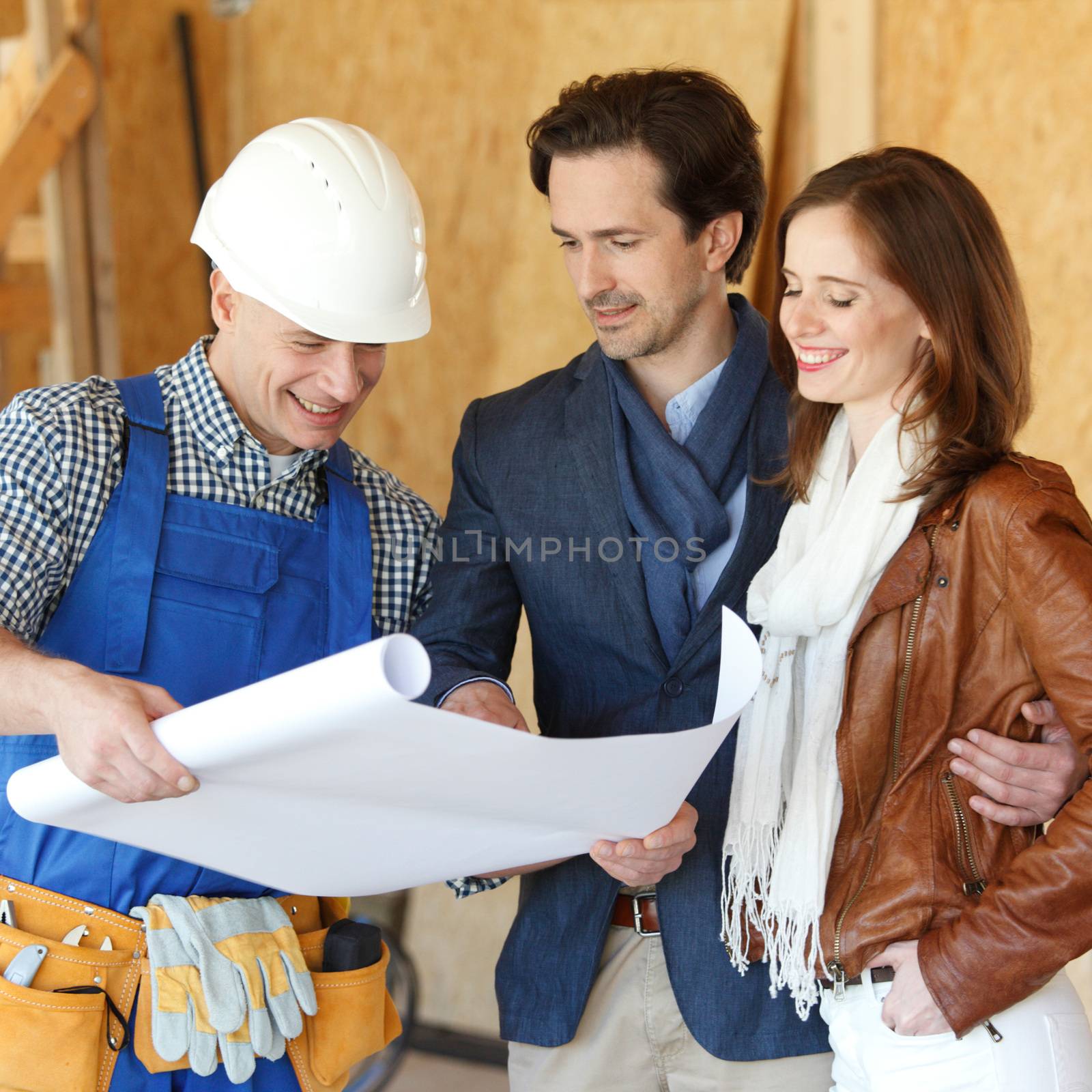 Foreman shows house design plans to a young couple