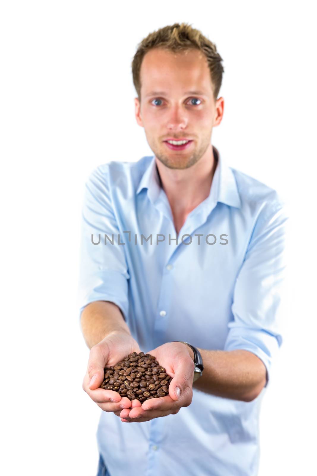 Young salesman showing hands full with coffee beans isolated on white background