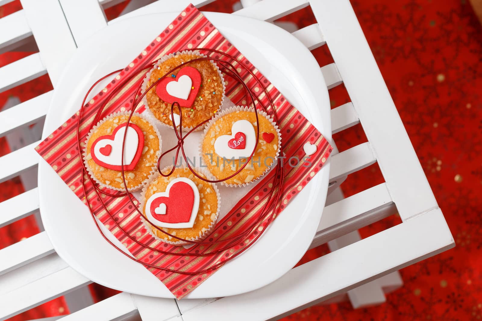 white plate with valentine's day muffins with red and white hearts on a white wooden table