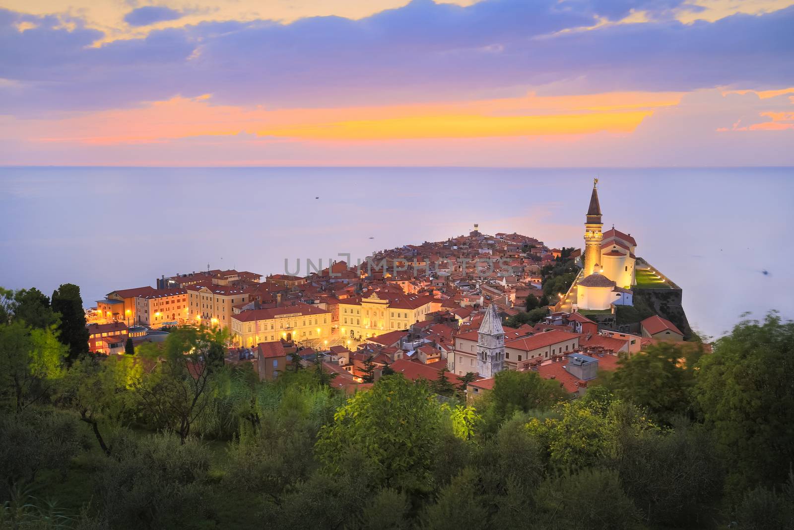 Romantic colorful sunset over picturesque old town Piran, Slovenia. Senic panoramic view. Horizontal composition.