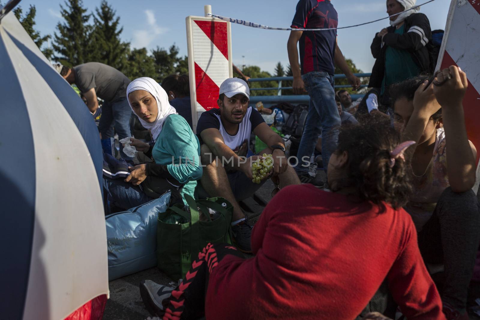 CROATIA, Harmica: Refugees sit and wait on a bridge in the village of Harmica, Croatia on the border of Slovenia on September 19, 2015, after the Slovenian government blocked refugees from entering the country with riot police. Slovenia is the latest country to be forced into action over the global refugee crisis, with Slovenia's ambassador to Germany telling the Rheinische Post newspaper they will accept 'up to 10, 000' refugees