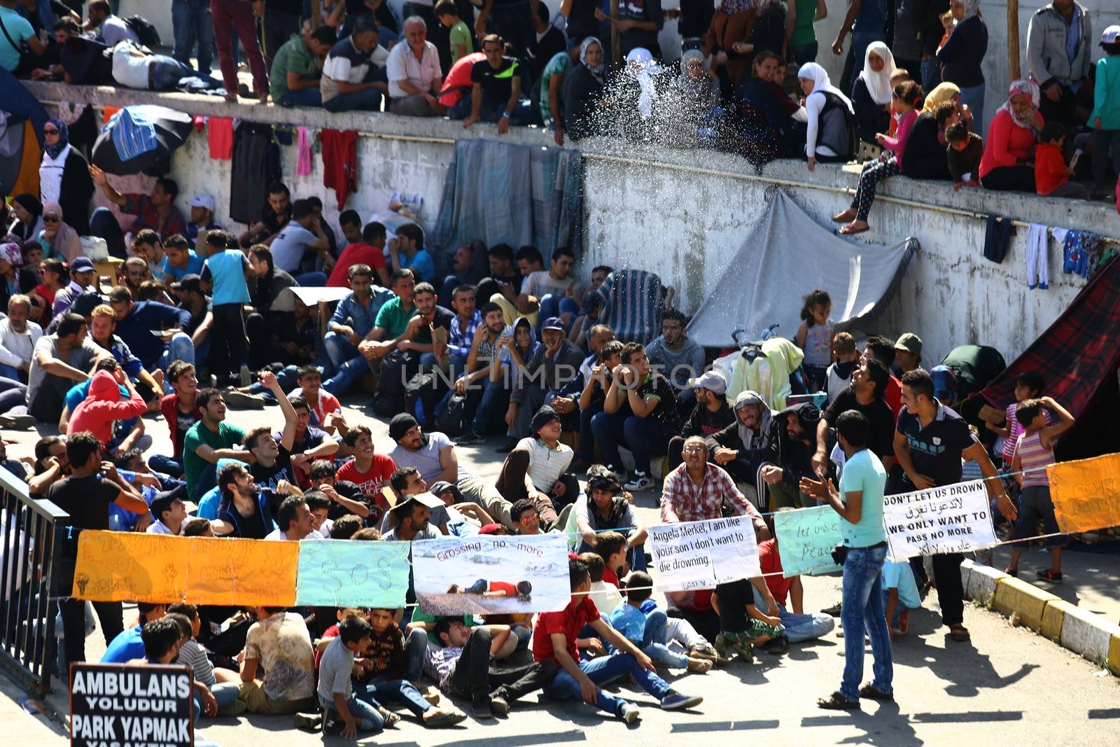 TURKEY, Istanbul: Refugees sit and wait near the Esenler Bus Terminal in Istanbul, Turkey on September 19, 2015 after the government ordered that bus tickets not be sold to them. They are waiting for the government to reverse the decision so they can travel to the Turkish border town of Edirne to continue their journey into Europe