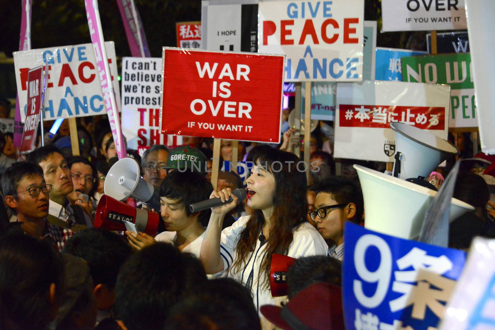 JAPAN, Tokyo: Protestors hold signs near Japanese parliament in Tokyo, Japan, on September 15, 2015 during a demonstration against security law. Demonstrators claim Japanese Prime minister Shinzo Abe's resignation.