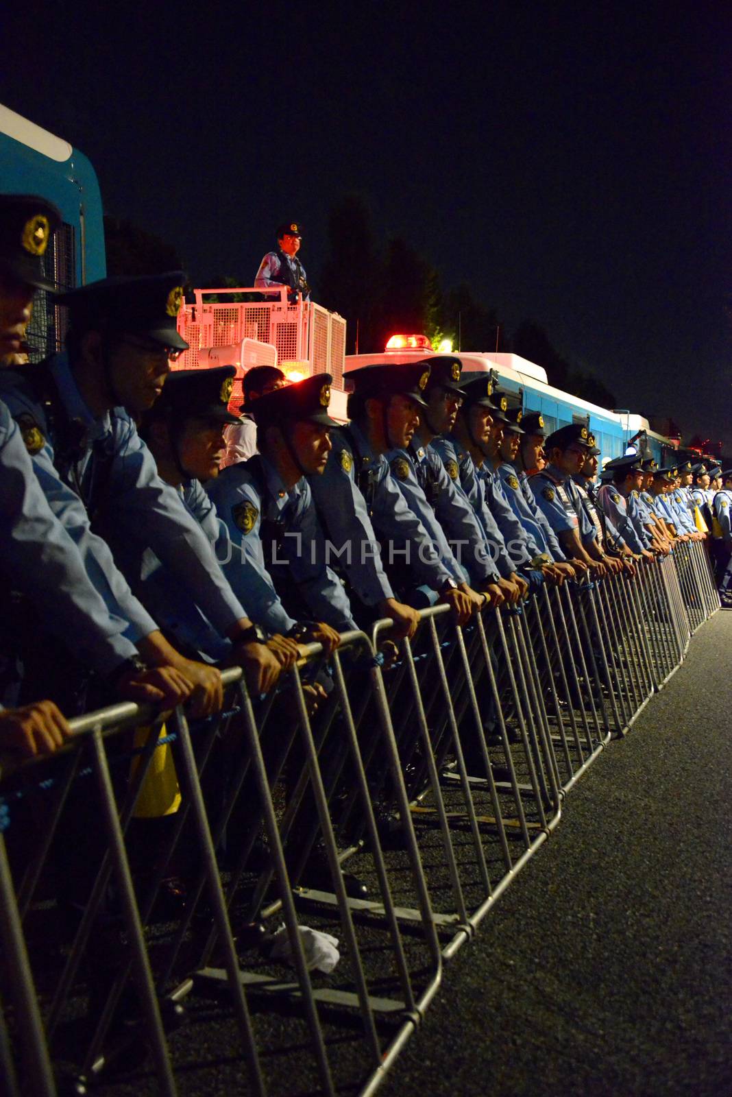 JAPAN, Tokyo: Police officers stand in line behind barriers near Japanese parliament in Tokyo, Japan, on September 14, 2015 during a demonstration against security law. Demonstrators claim Japanese Prime minister Shinzo Abe's resignation.