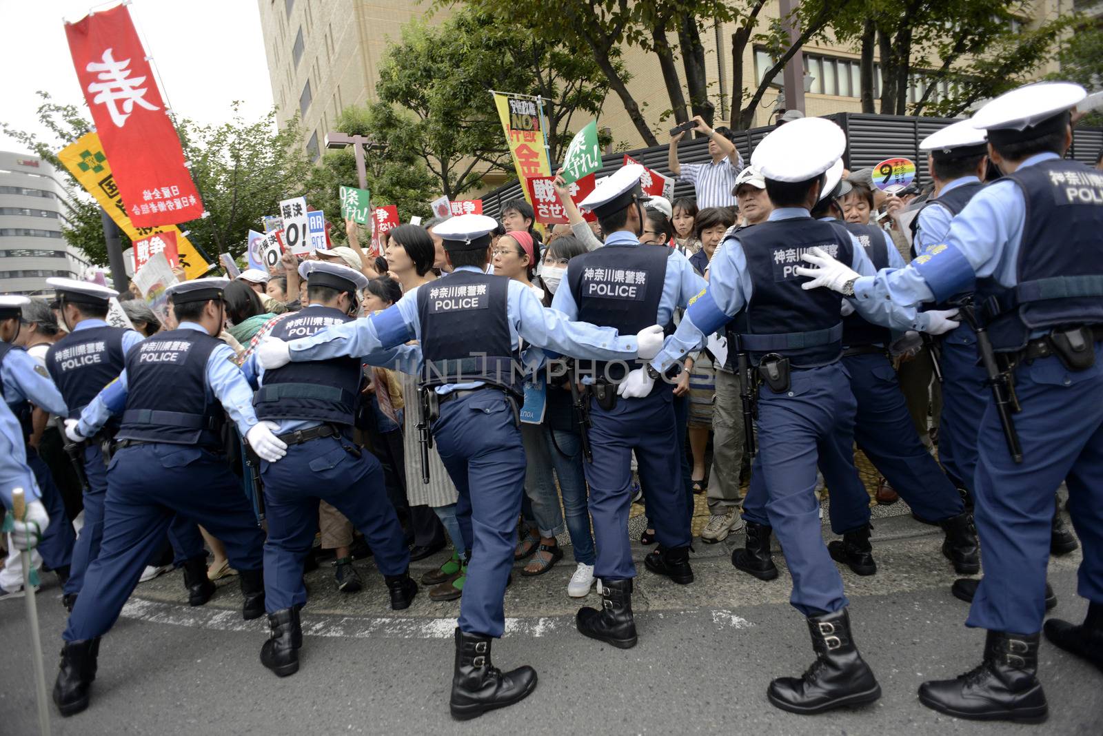 JAPAN, Yokohama: Police officers contain protestors in Yokohama, Japan, on September 16, 2015 during a demonstration against security law. Demonstrators claim Japanese Prime minister Shinzo Abe's resignation.