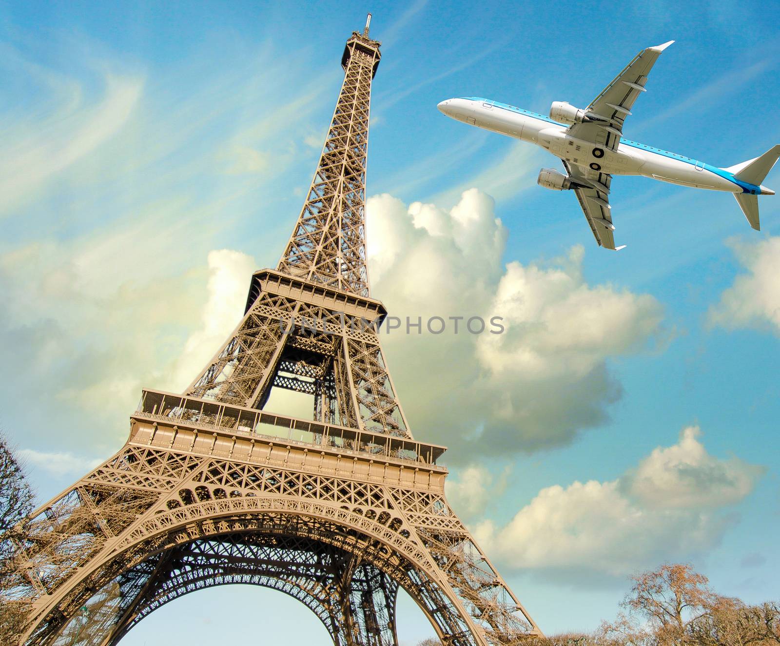 Airplane overflying Eiffel Tower in Paris.