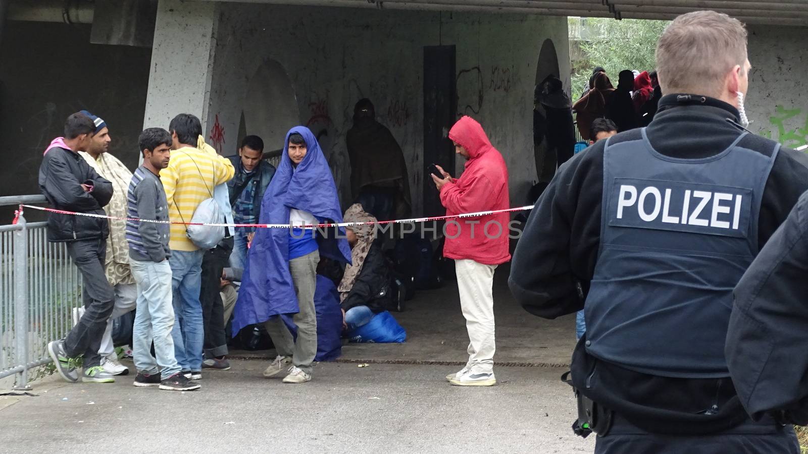AUSTRIA, Saalachbruecke: Hundreds of migrants wait in cold and rainy weather at the border in Austria hoping to cross into the town of Freilassing in Germany on September 20, 2015.  Many migrants are seeking asylum in either Germany or Sweden, but those countries are calling on their EU partners to show solidarity and share the responsibility. 	