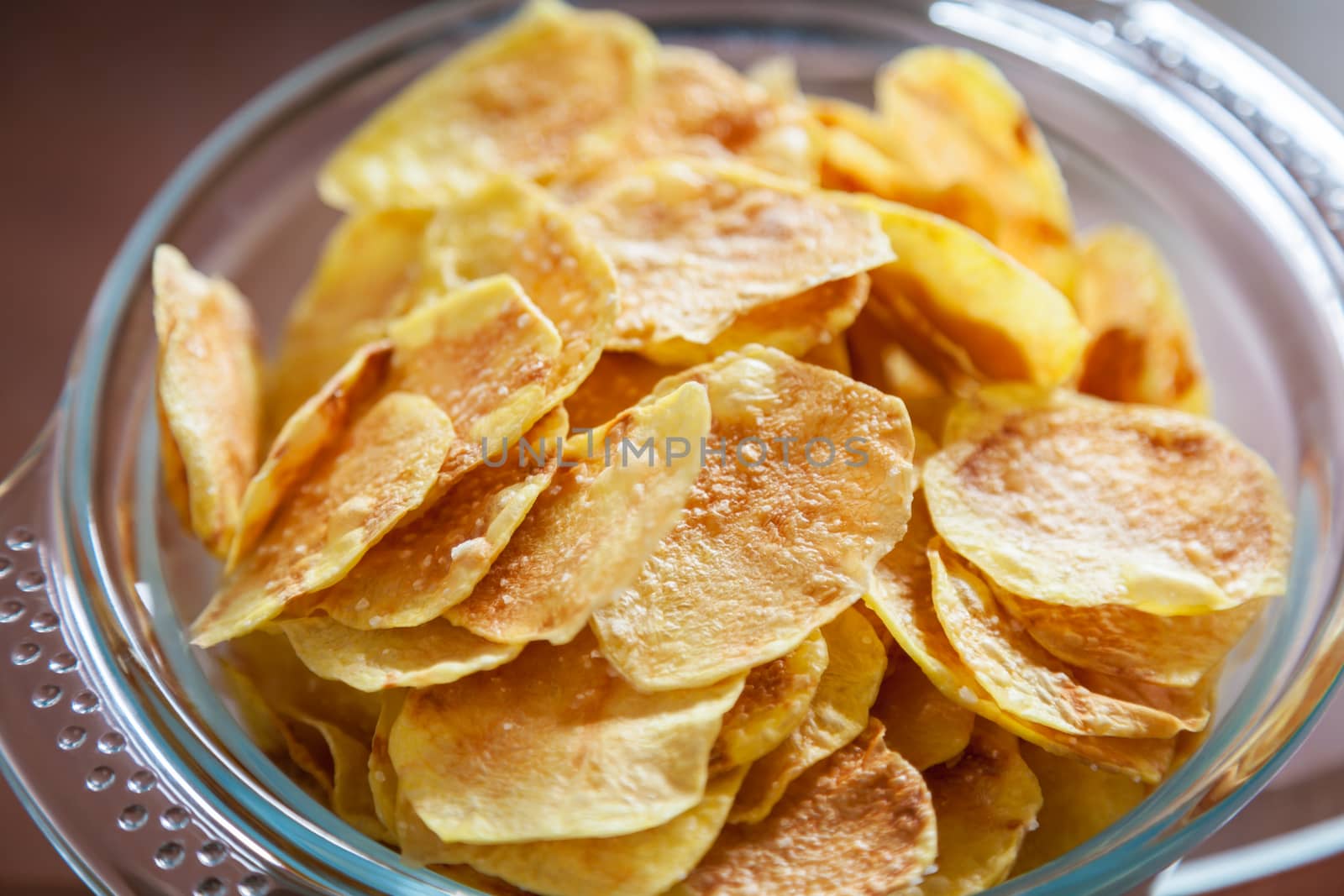 Delicious homemade potato chips in a glass bowl