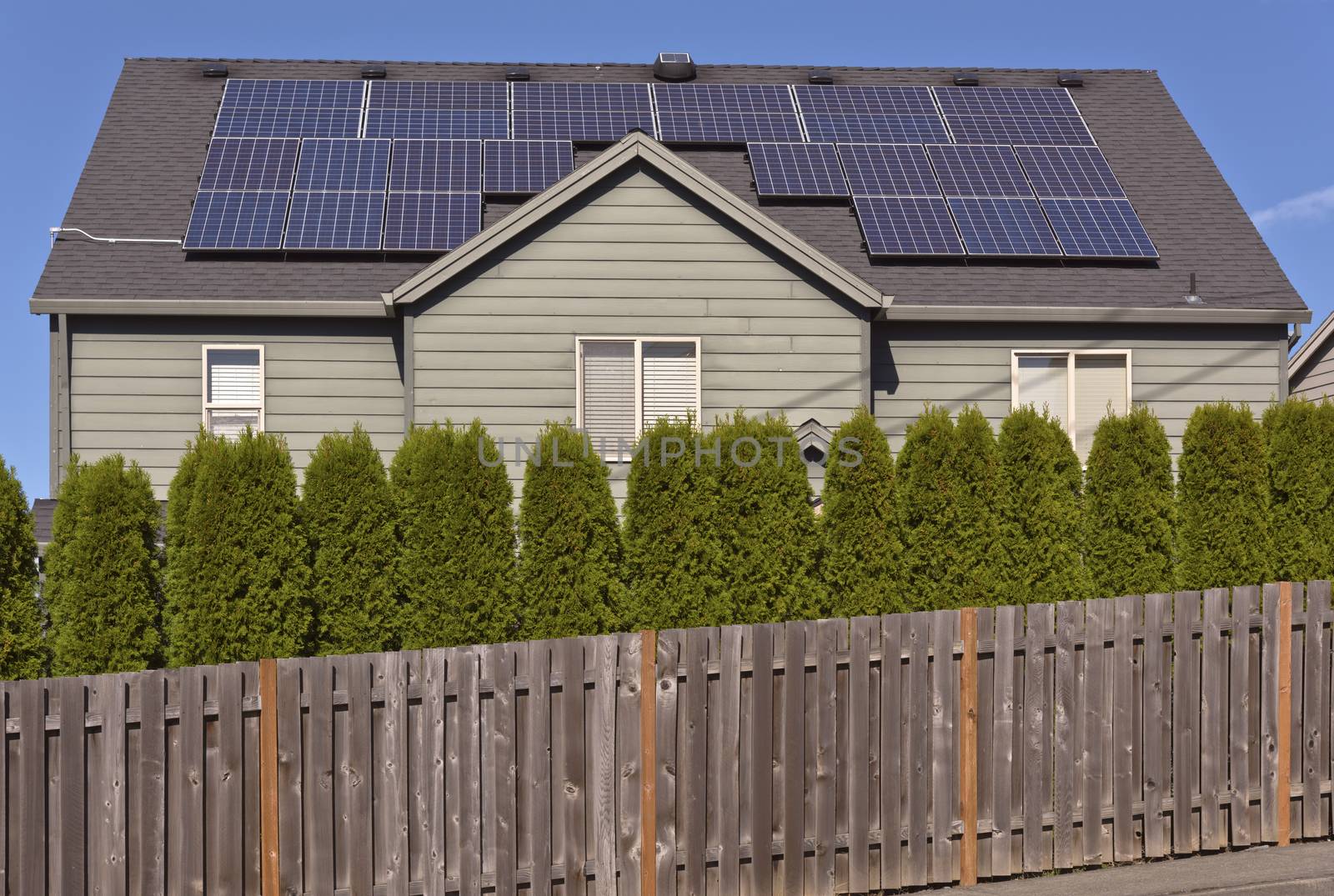 Solar panels facing the sun on a roof of a house.