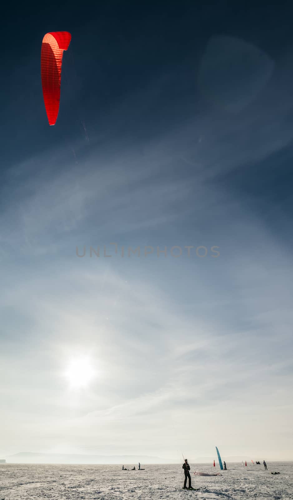 Kite surfer being pulled by his kite across the snow