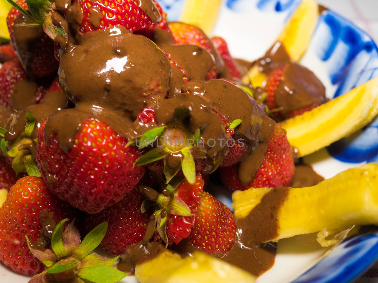 Banana and strawberry under hot chodolate on traditional russian plate - gzhel