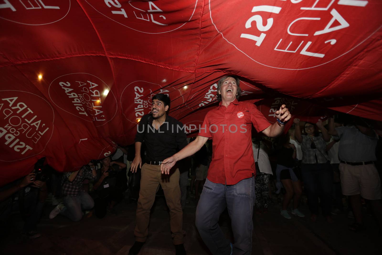 GREECE, Athens: Syriza supporters celebrate with a large flag from the 'L'Altra Europa con Tsipras' Italian party as Syriza leader Alexis Tsipras addressed supporters in Athens after claiming victory in Greece's parliamentary election on September 20, 2015.