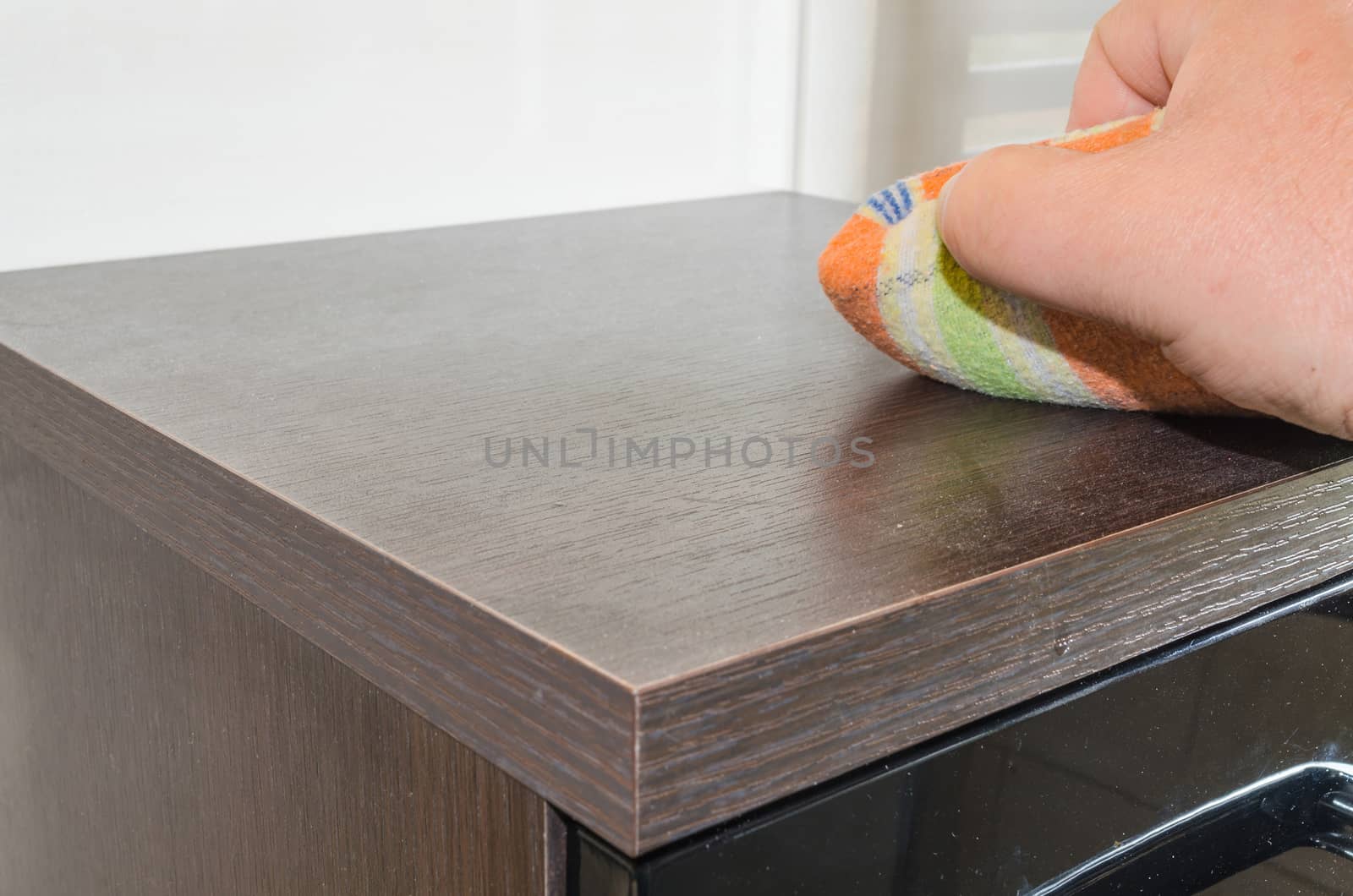 Wipe the dust. Duster in one hand.