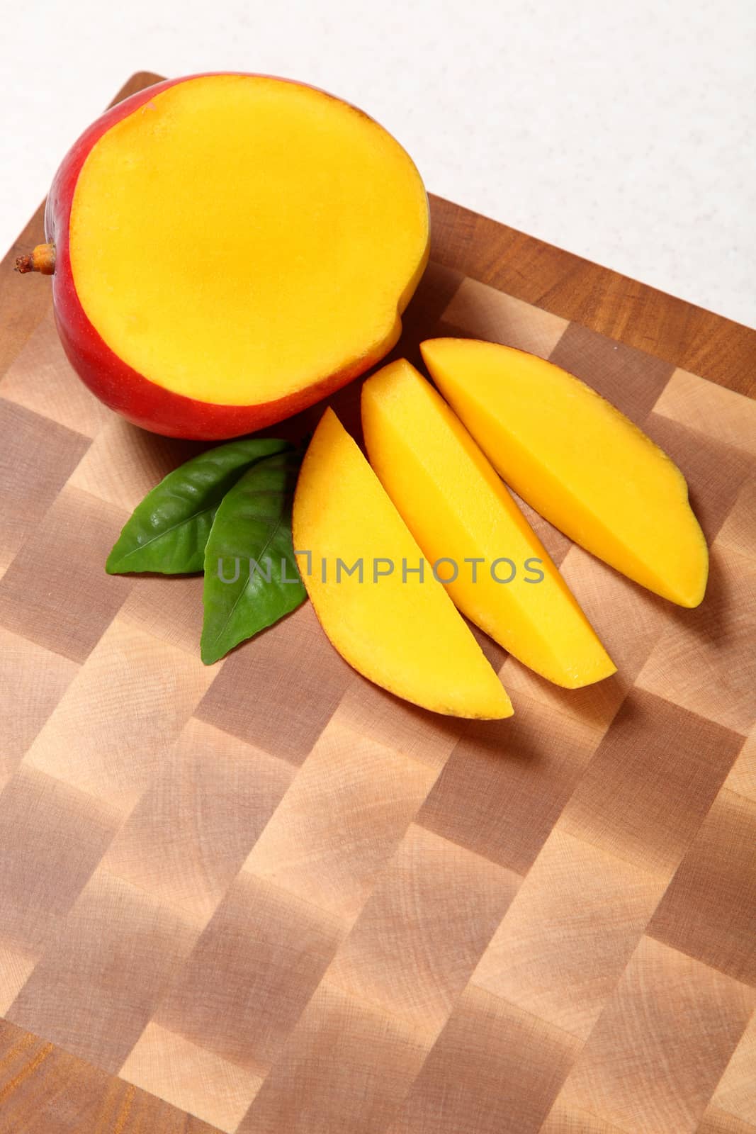 Cut by mango segments on a chopping board