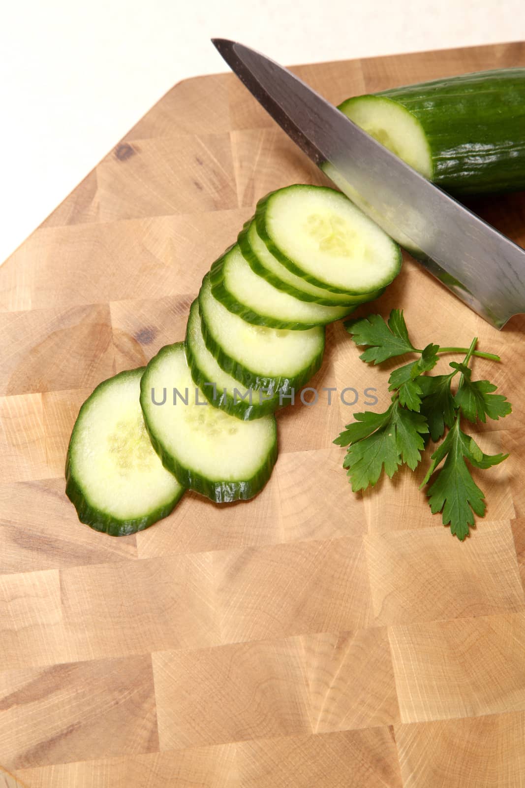 The cucumber cut by means of a knife, the leaf of parsley lying on a chopping board