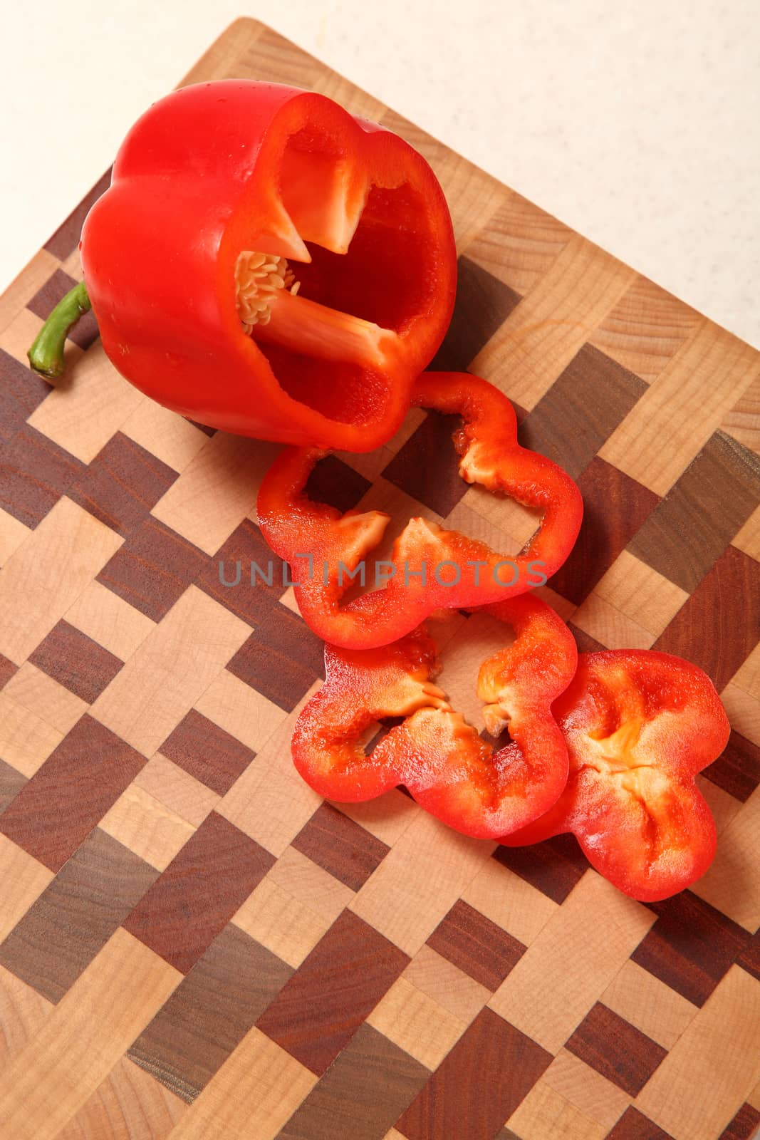 segments of red pepper on a wooden chopping board