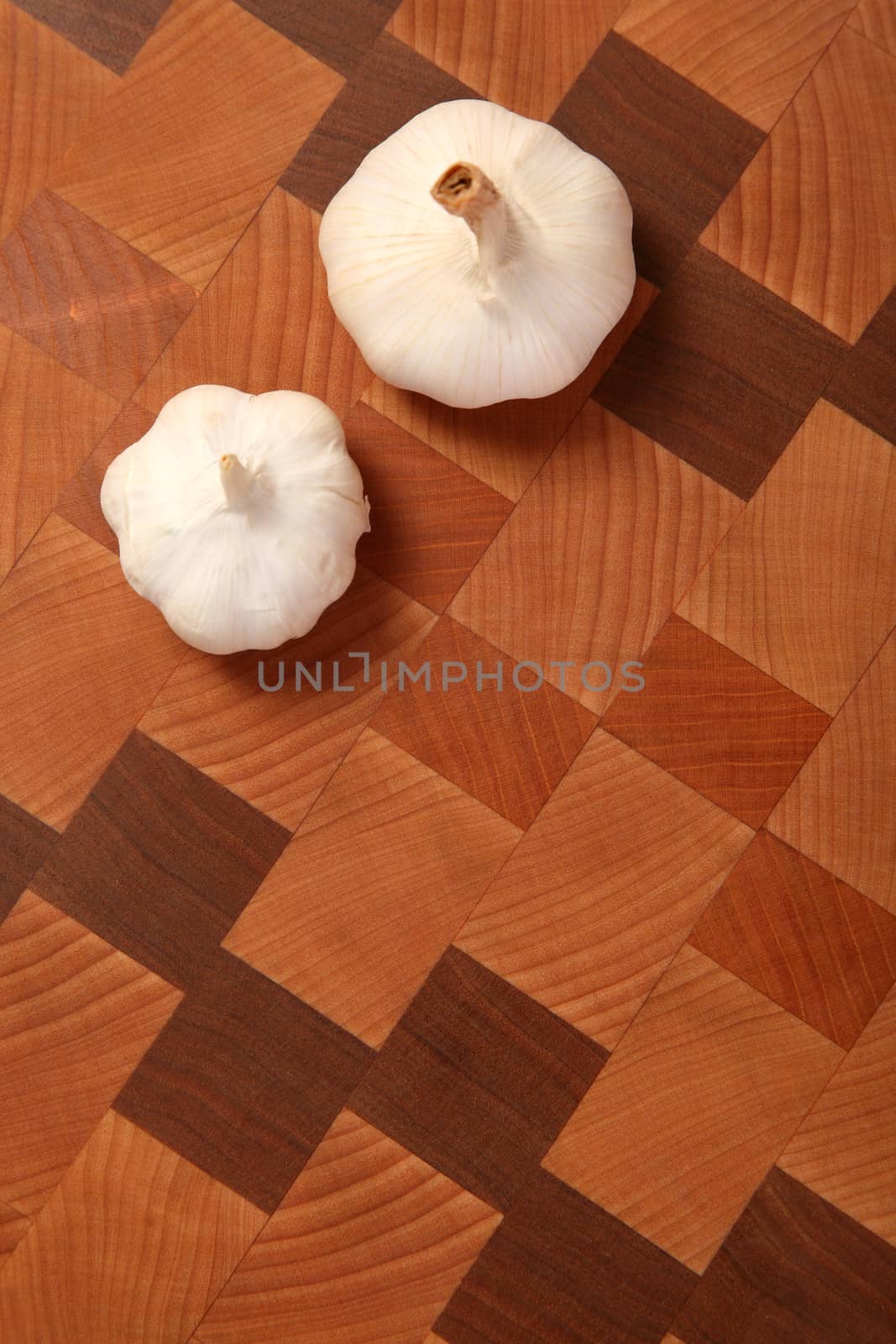 two heads of garlic on a chopping board