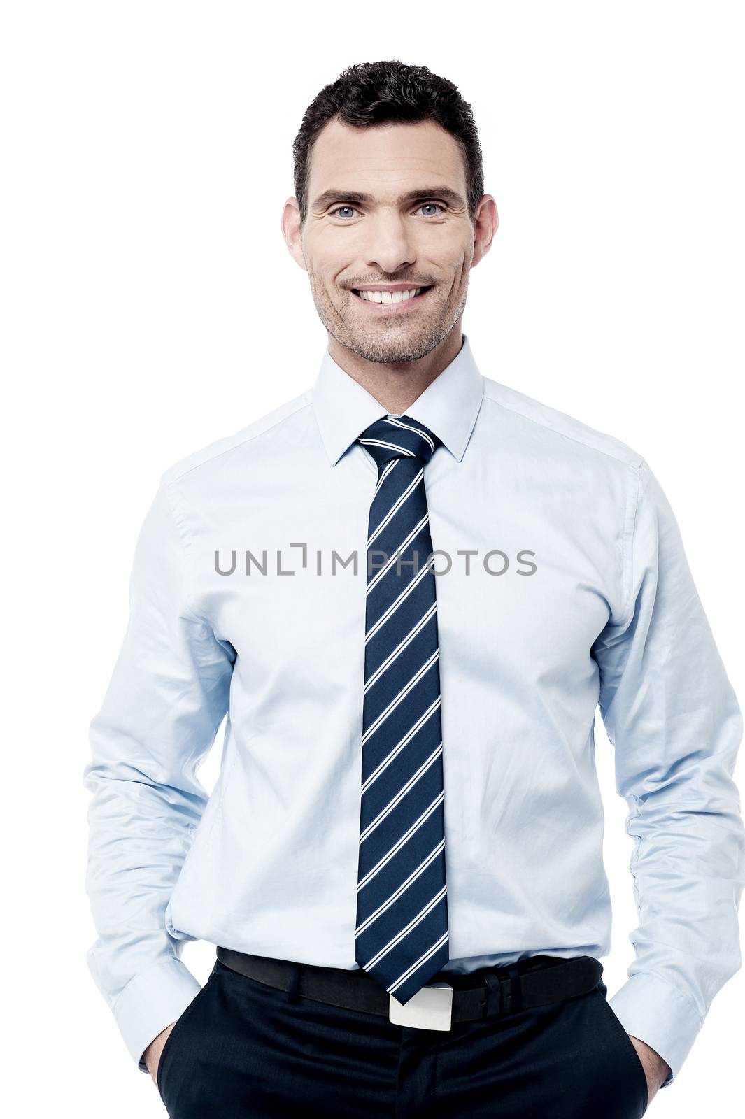 Smiling male executive posing with hands in pockets