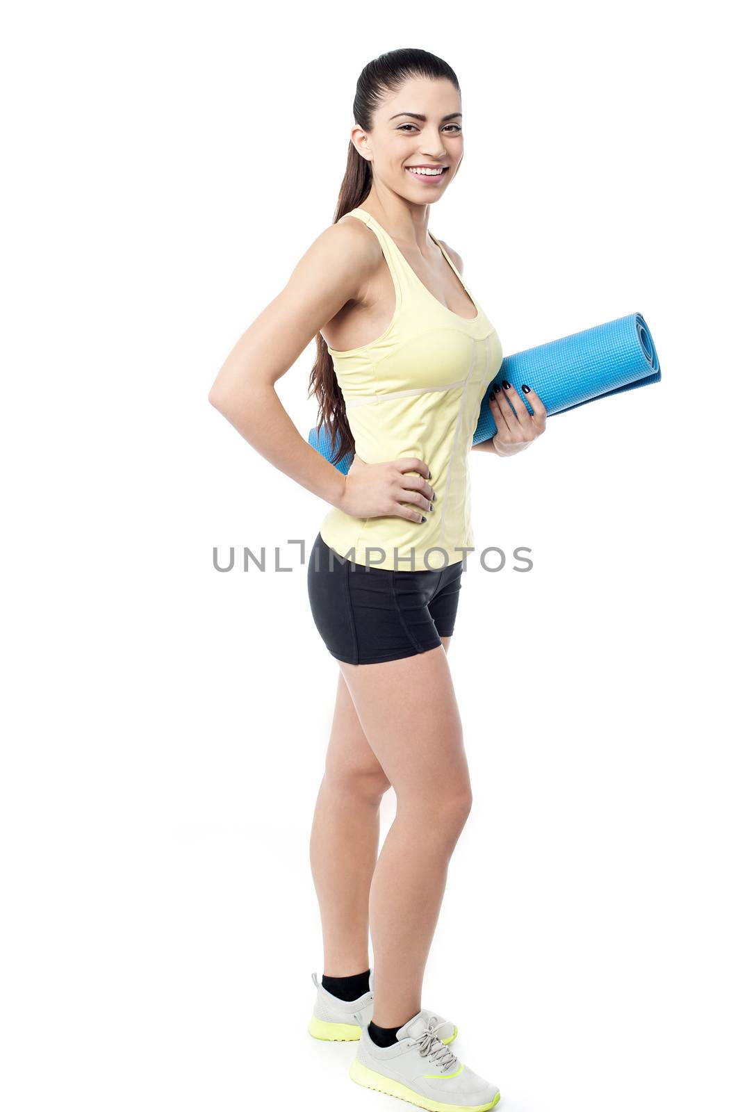 Young woman with rolled up exercise mat