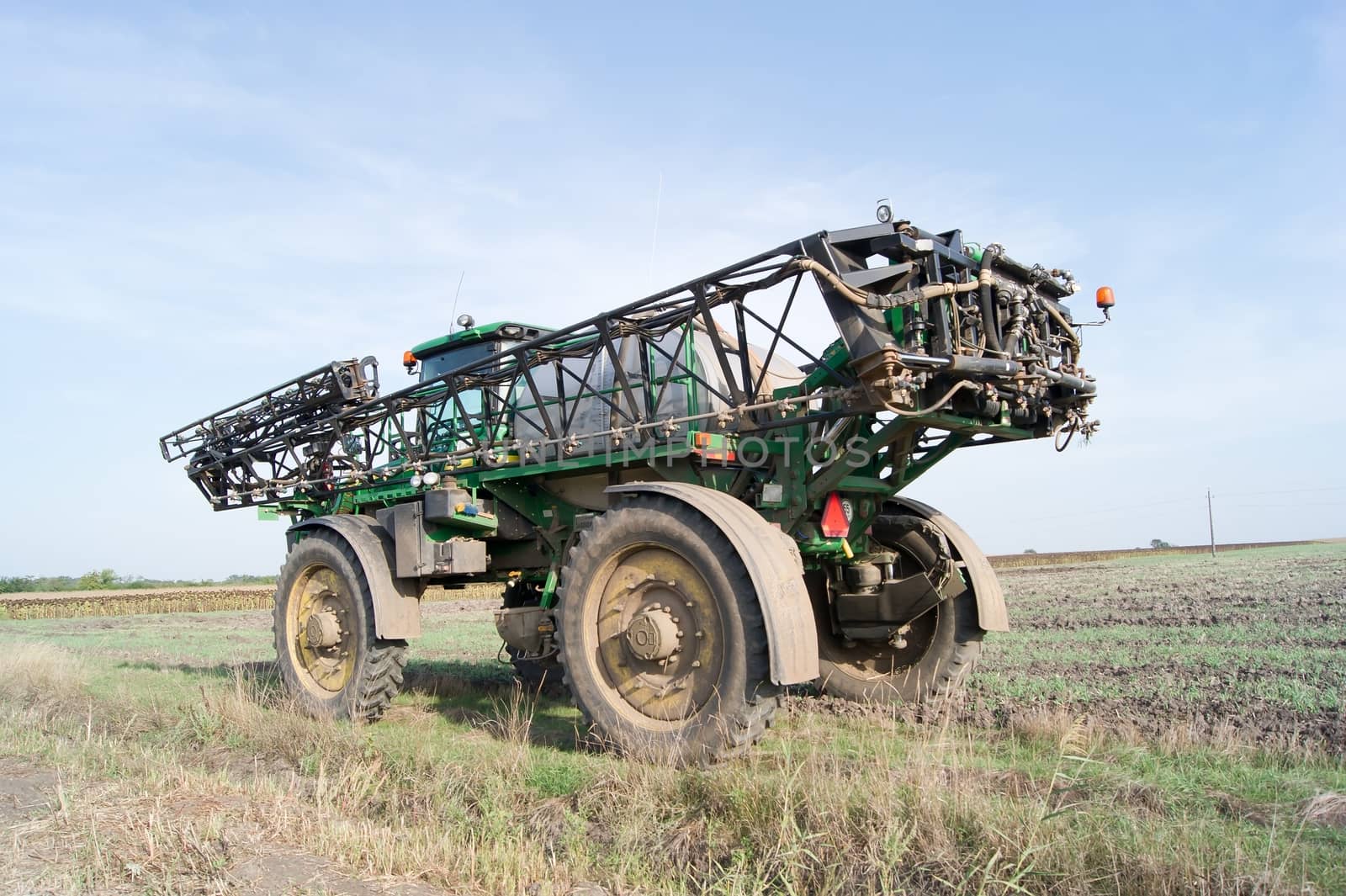 The sprayer tractor working on a big field.