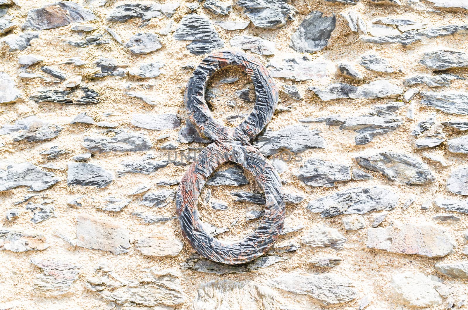 Old castle stone wall with speed Nr. 8 in wrought iron. texture background