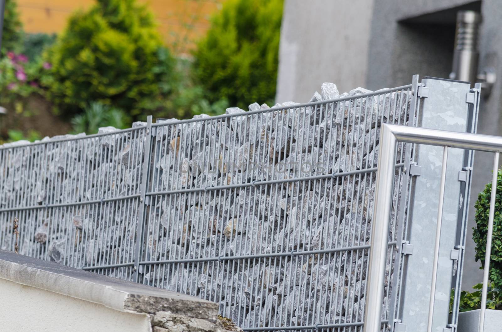 Gabions filled with natural stone as a demarcation to the neighboring properties.
