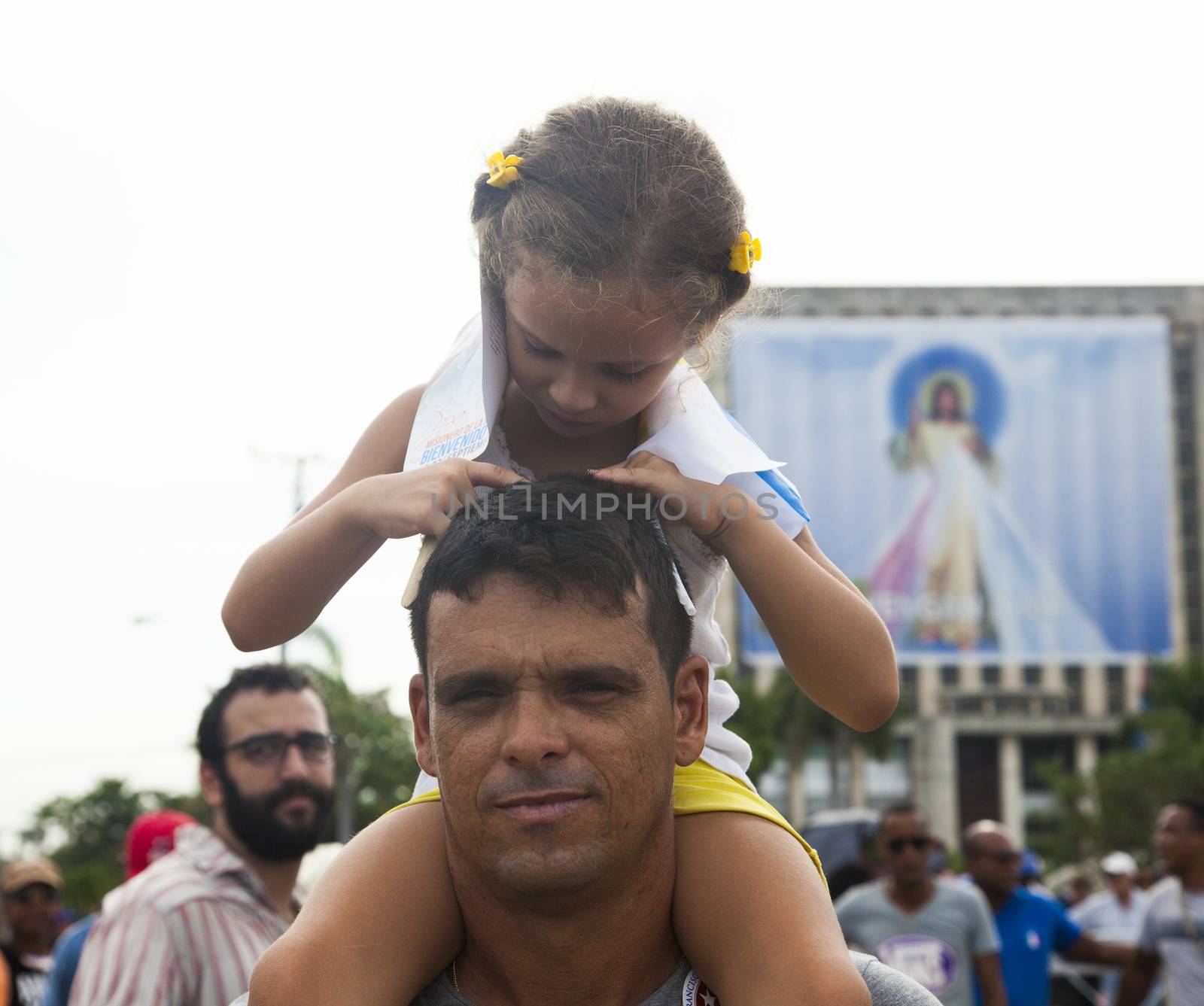 CUBA, Havana: A Cuban man and his child are pictured as Pope Francis celebrates mass in Revolution Square, in Havana, on September 20, 2015. Pope Francis is on the first full day of his three day visit to Cuba, where he meets President Raul Castro and Fidel Castro and hold Mass in Revolution Square before travelling to Holguin, Santiago de Cuba and El Cobre, then onwards to the United States.