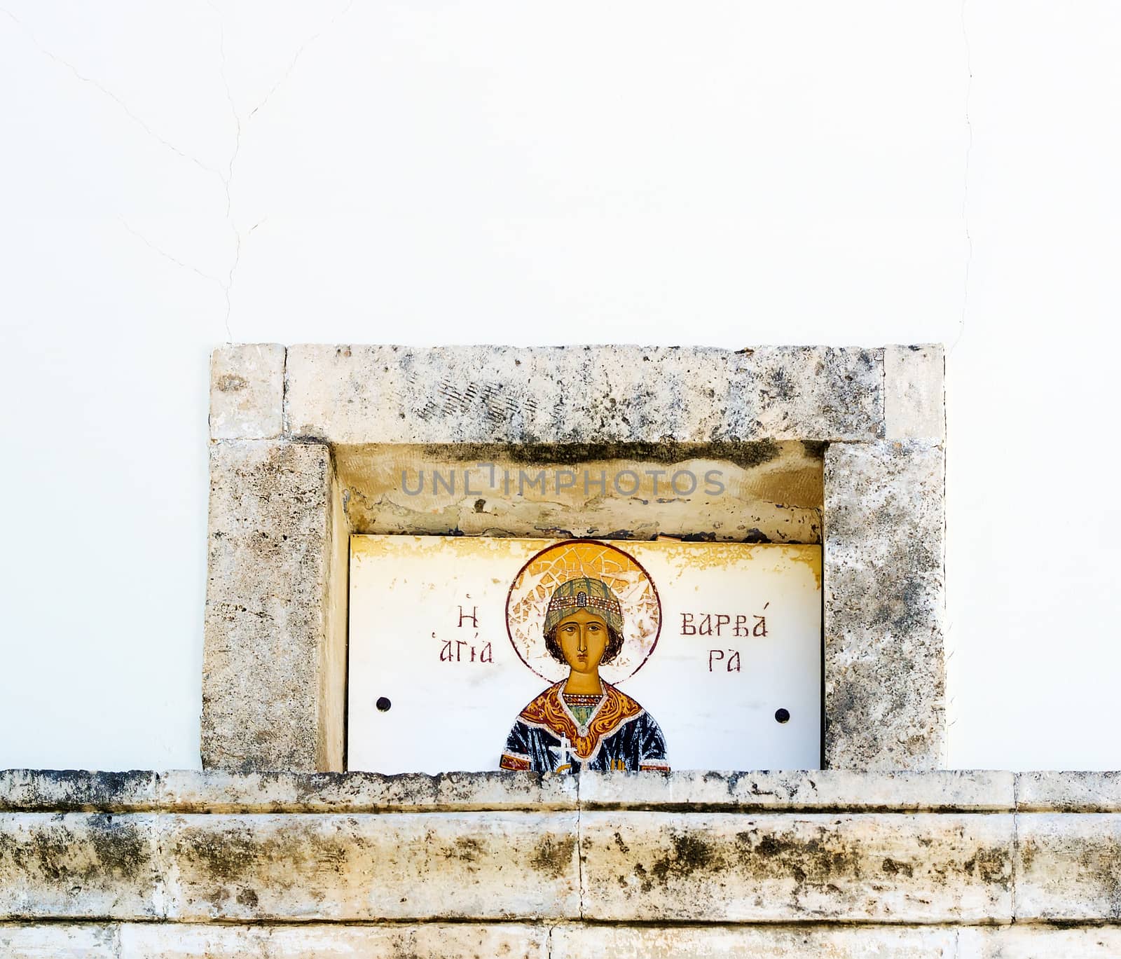 On the white facade of the Church of St. Barbara in the town of Rethymno, island of Crete is an old picture of St. Barbara.