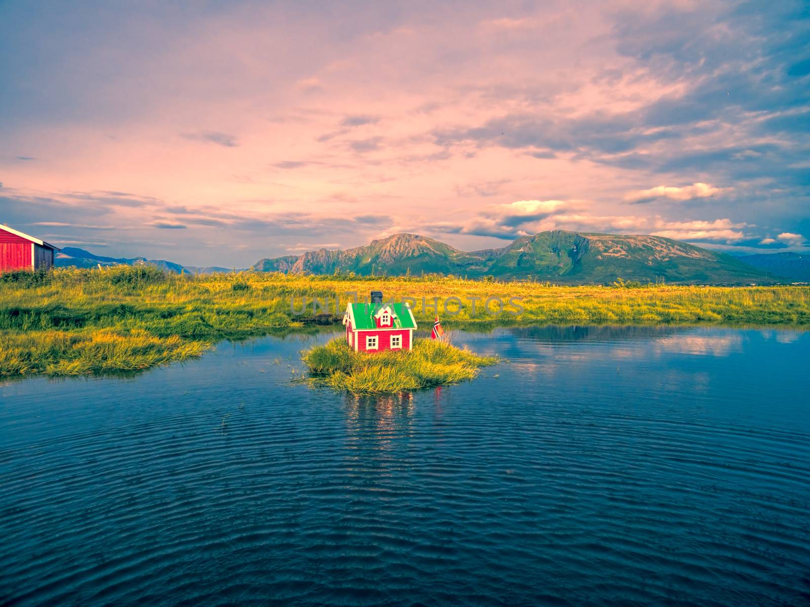 Romantic miniature scandinavian red house on tiny islet