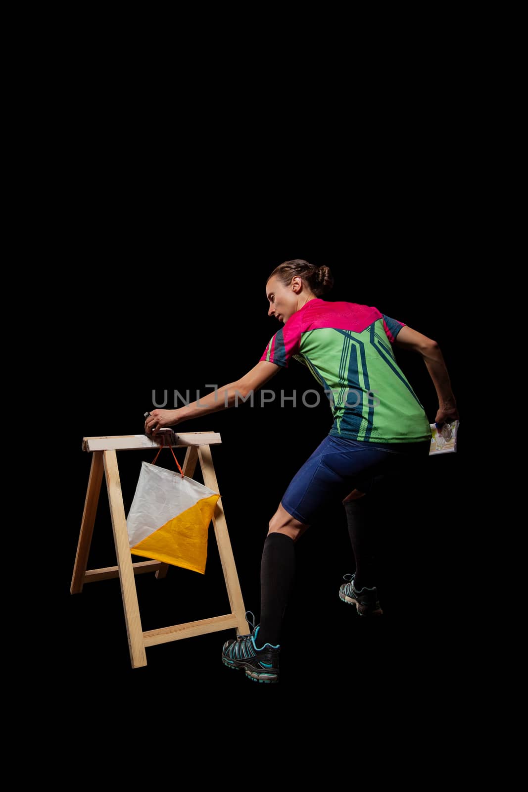 Woman punching at control point, taking part in orienteering competitions. Isolated on black. File contains clipping path