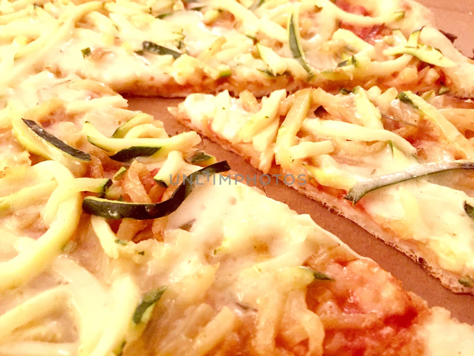 Aereal view of a slice of pizza with zucchini and potatoes cut  in thin slices in a cardoard box