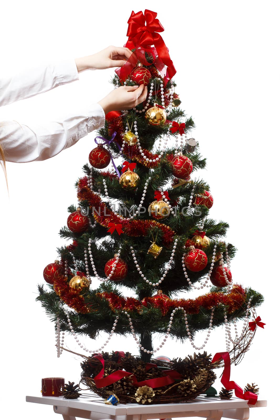 Decorating christmas tree with balls, ribbons and stuff, isolated on white background