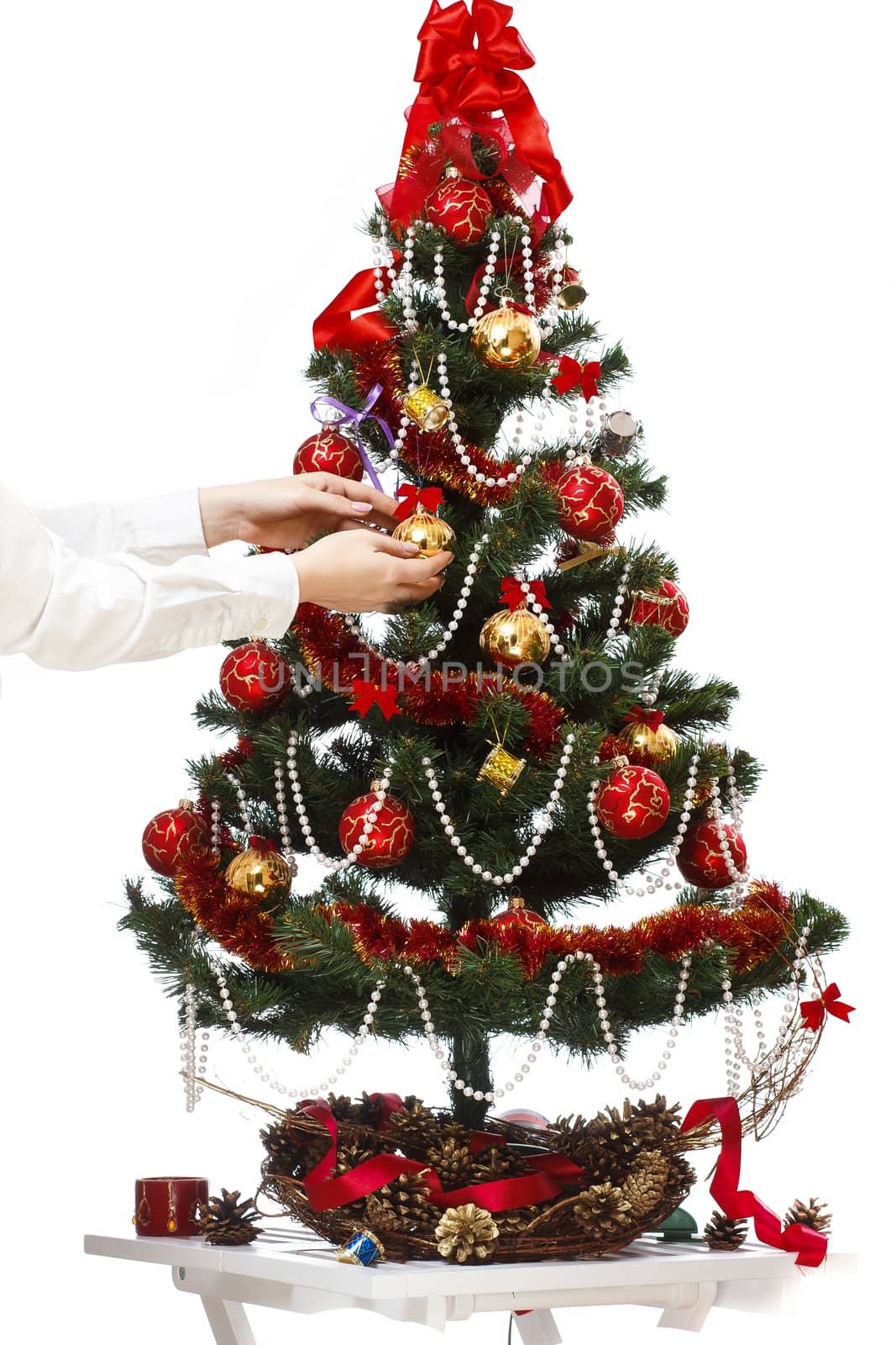 Decorating christmas tree with balls, ribbons and stuff, isolated on white background