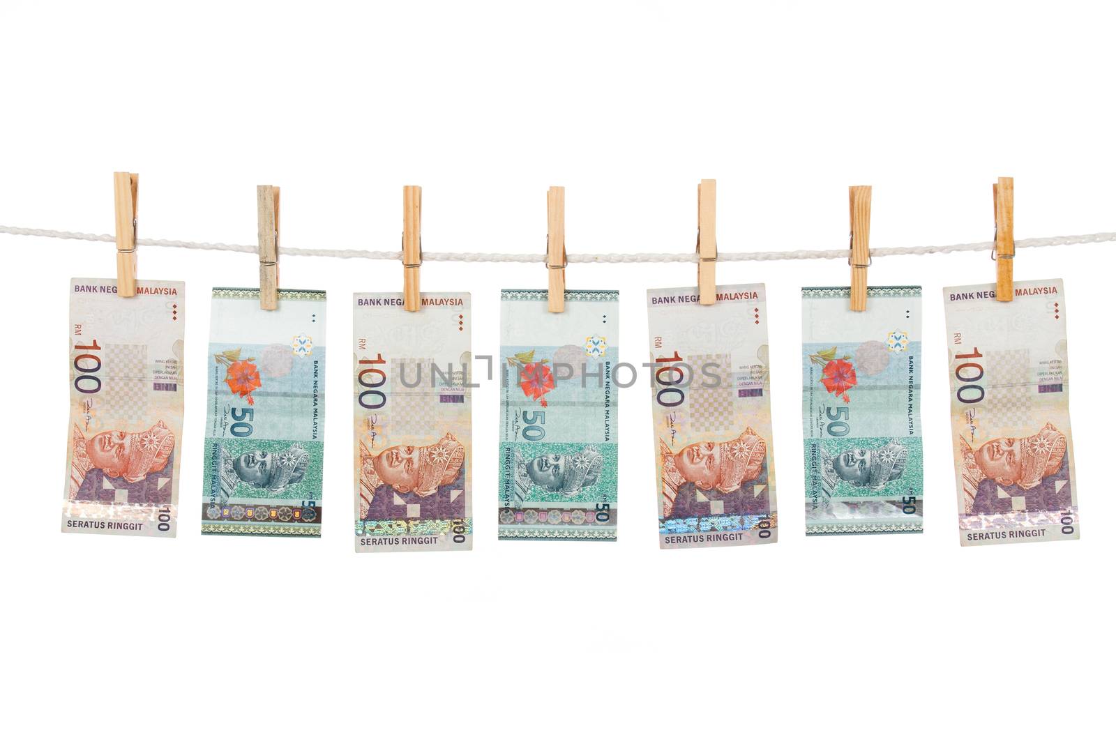 Money laundering concept with Ringgit Malaysia notes on clothesline in plain isolated white background.