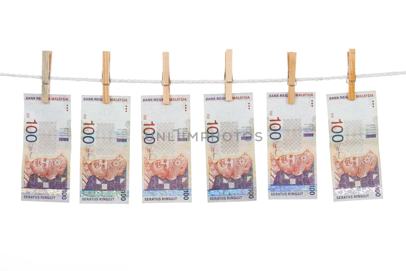 Money laundering concept with Ringgit Malaysia notes on clothesline in plain isolated white background.
