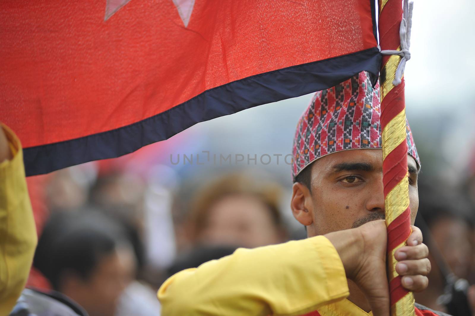 NEPAL, Kathmandu: A man holds a flag at celebrations in Kathmandu, Nepal on September 21, 2015, one day after the government unveiled the country's first democratic constitution in a historic step. Out of the 598 members of the Constituent Assembly, 507 voted for the new constitution, 25 voted against, and 66 abstained in a vote on September 16, 2015. The event was marked with fireworks and festivities, but also with protests organized by parties of the Tharu and Madhesi ethnic communities.Photos taken by Newzulu contributor Narayan Maharjan show the Nepalese people donning traditional garb and celebrating with folk music and dancing.