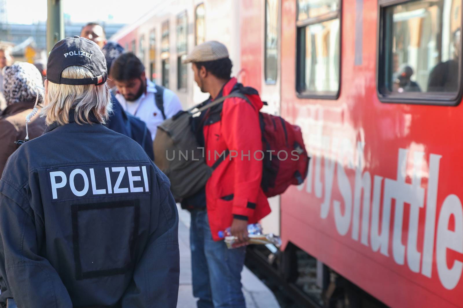 GERMANY, Passau: Security officials stand guard as refugees wait in long queues in the border town of Passau, Germany on September 21, 2015 amid the reintroduction of border controls in Germany, Austria, and a number of other EU countries, aimed at slowing the flow of refugees from war-torn Syria.