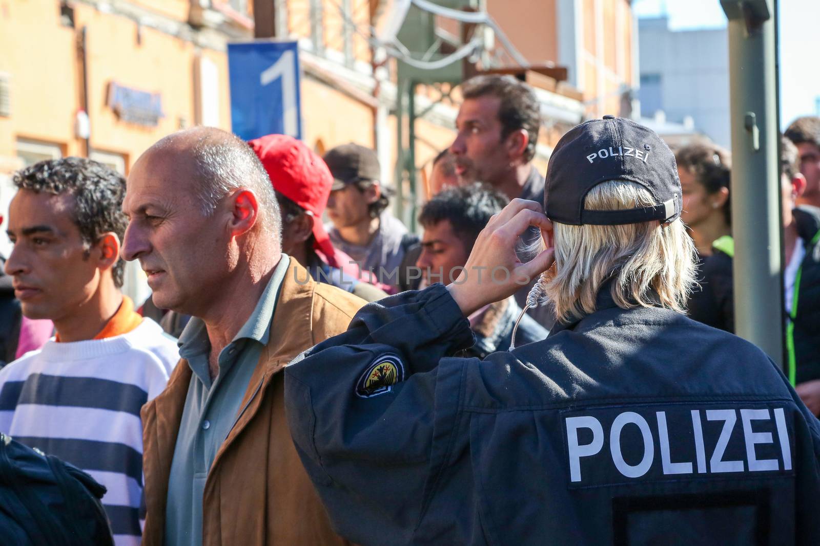 GERMANY, Passau: Security officials stand guard as refugees wait in long queues in the border town of Passau, Germany on September 21, 2015 amid the reintroduction of border controls in Germany, Austria, and a number of other EU countries, aimed at slowing the flow of refugees from war-torn Syria.