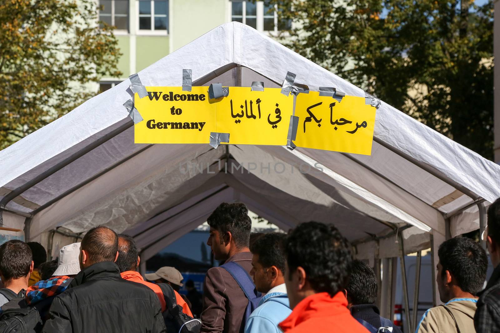 GERMANY, Passau: A sign reads Welcome to Germany as refugees wait in long queues in the border town of Passau, Germany on September 21, 2015 amid the reintroduction of border controls in Germany, Austria, and a number of other EU countries, aimed at slowing the flow of refugees from war-torn Syria.