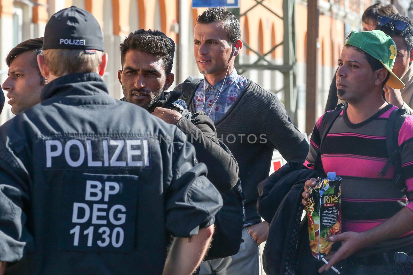  GERMANY, Passau: Security officials stand guard as refugees wait in long queues in the border town of Passau, Germany on September 21, 2015 amid the reintroduction of border controls in Germany, Austria, and a number of other EU countries, aimed at slowing the flow of refugees from war-torn Syria.
