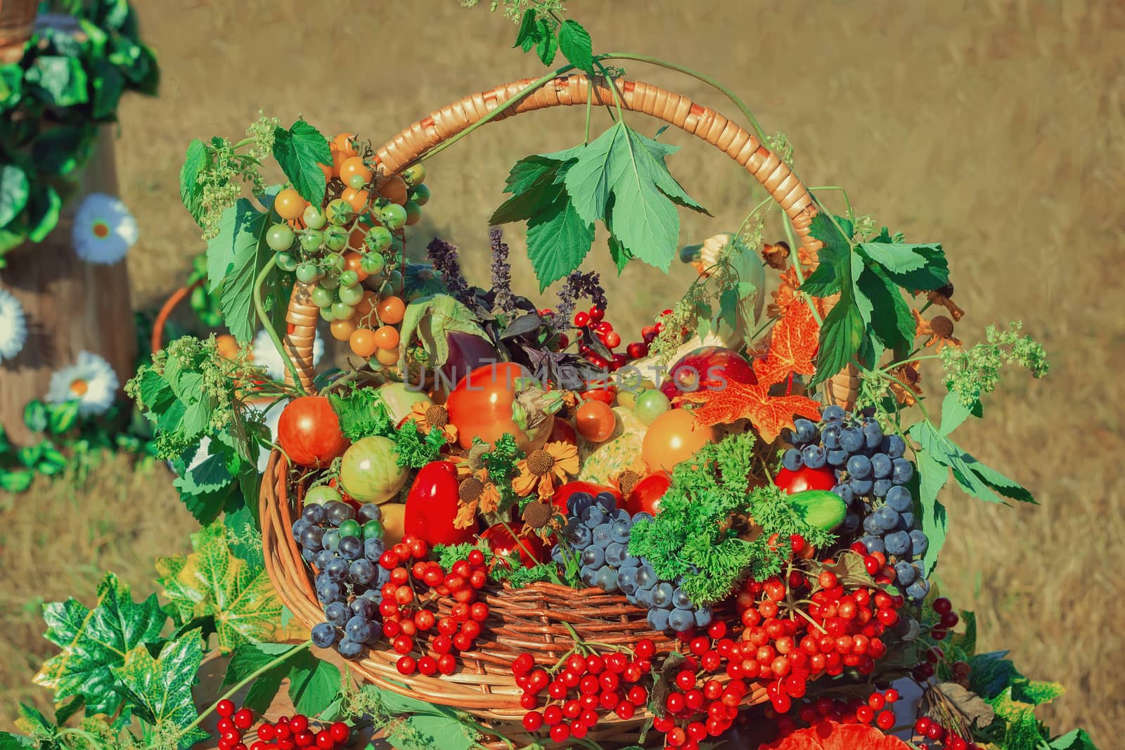 Large ripe apples , grapes, berries and vegetables are sold in beautifully decorated wicker basket at the fair.