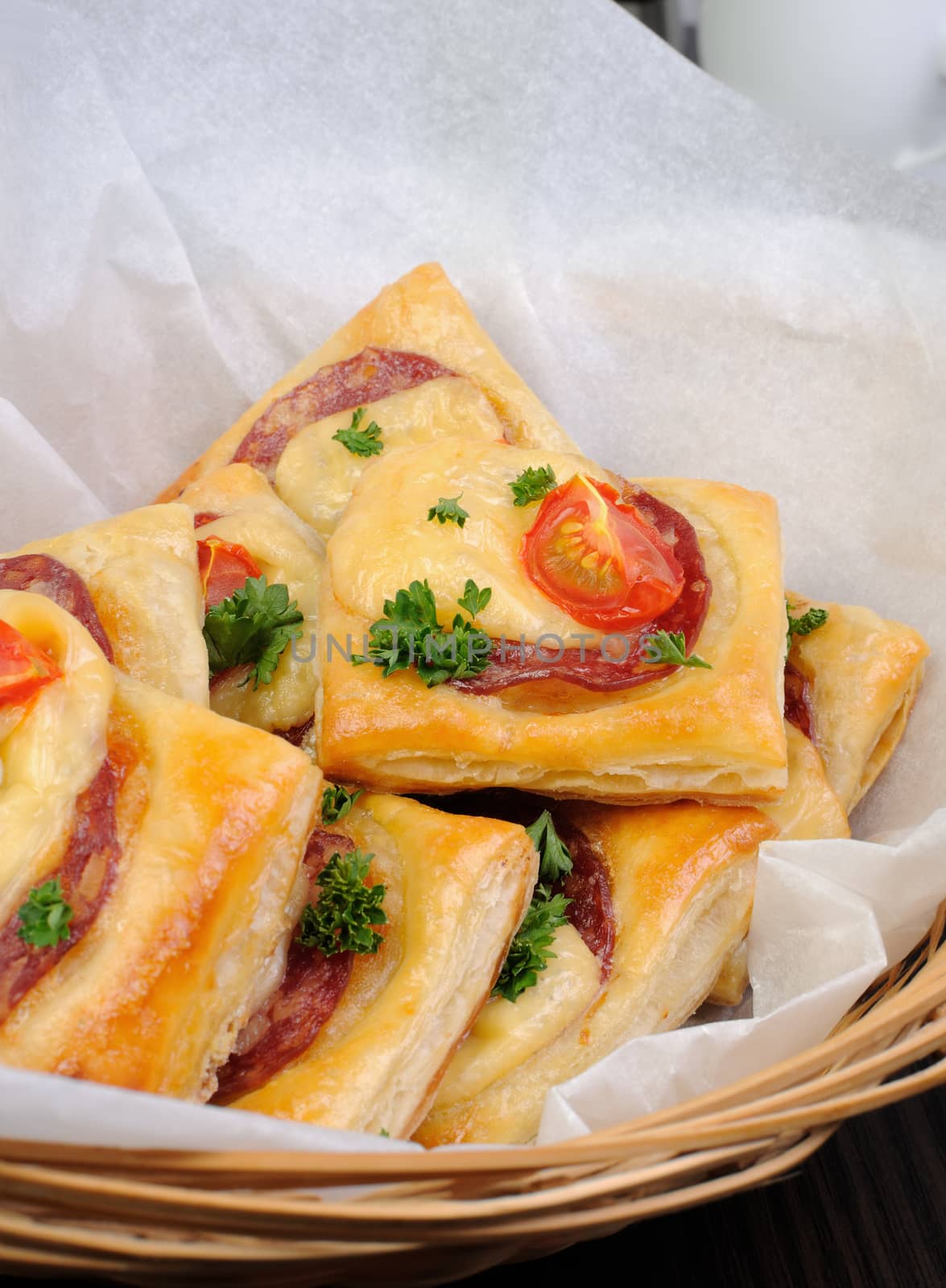 Appetizer of puff pastry with salami, cheese and cherry tomatoes