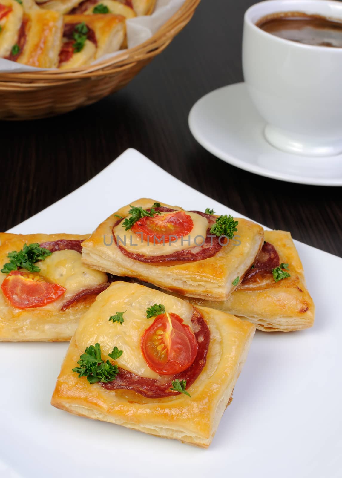 Appetizer of puff pastry with salami, cheese and cherry tomatoes