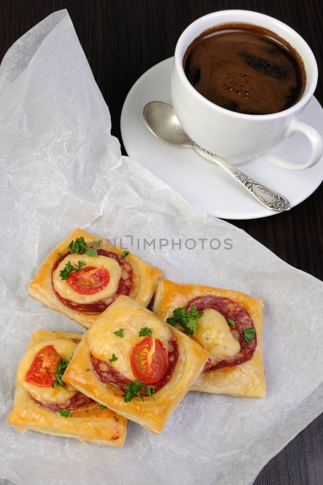 Appetizer of puff pastry with salami, cheese and cherry tomatoes