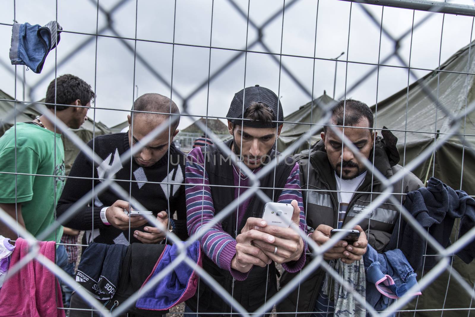 HUNGARY, Roszke: Refugees look at their phones as the difficulties of living in Hungary's Roszke refugee camp is documented between September 8 and 12, 2015, as Europe's refugee crisis continues. 