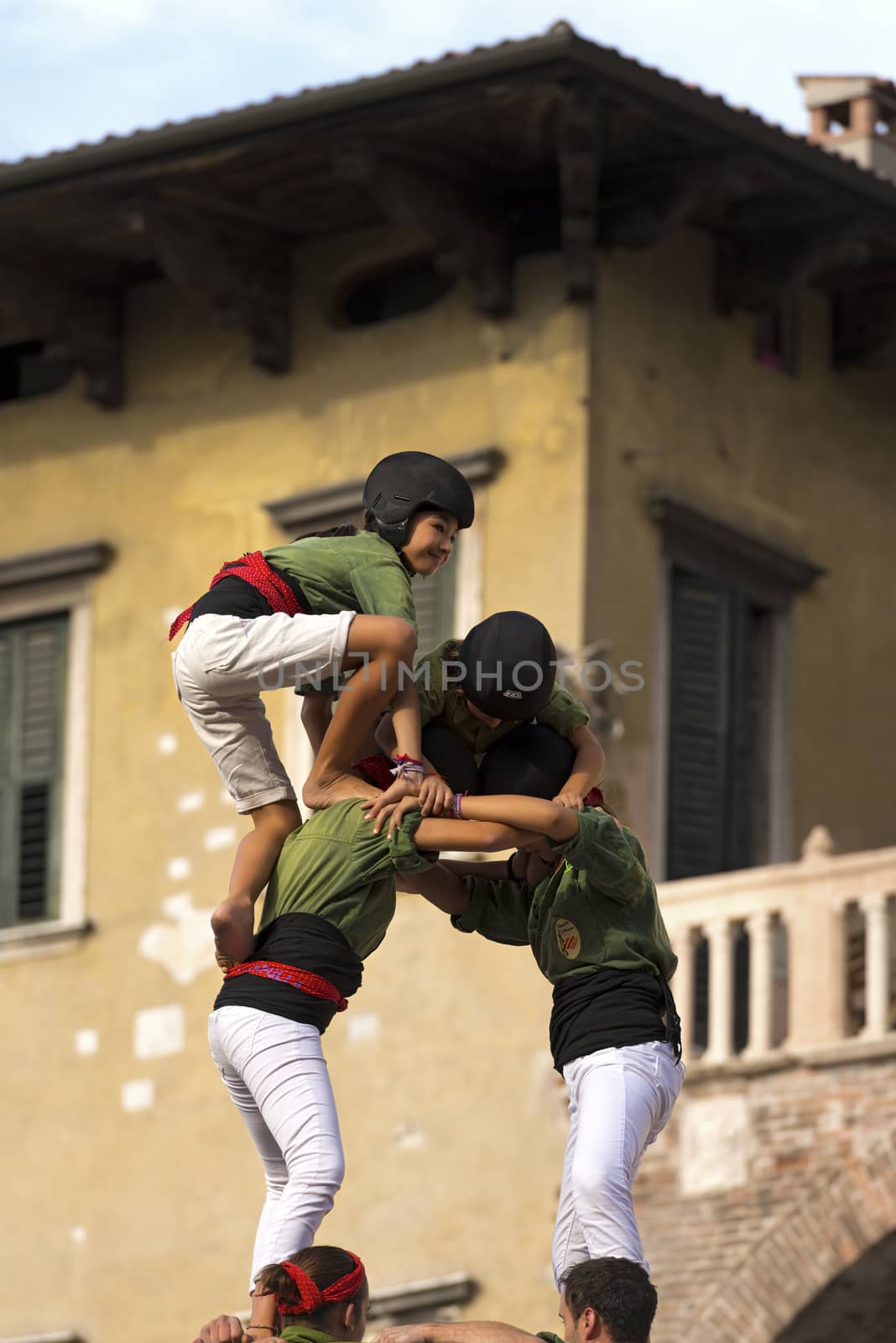 VERONA, ITALY - SEPTEMBER 19, 2015: Tocati, International festival of street games. Castells Performance of Xiquets d'Alcover of Tarragona, Catalonia, Spain. The Castells (Castle in Catalan) is a human tower - UNESCO intangible cultural heritage of humanity