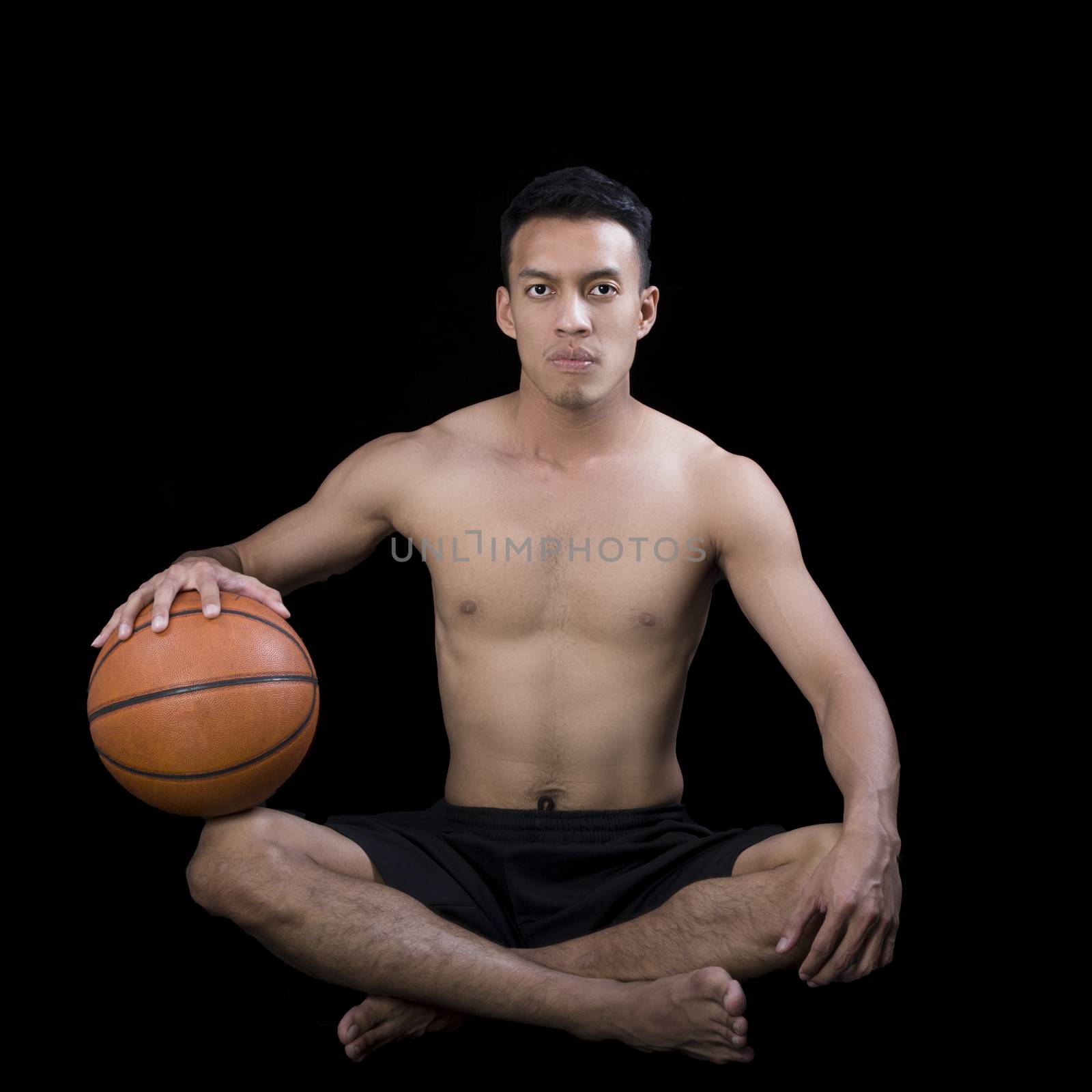 Asian young basketball player on black background